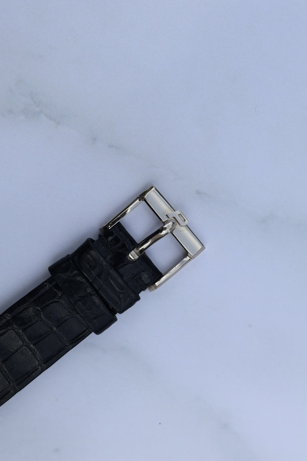 Original Piaget 18K white gold buckle with logo, attached to black leather strap