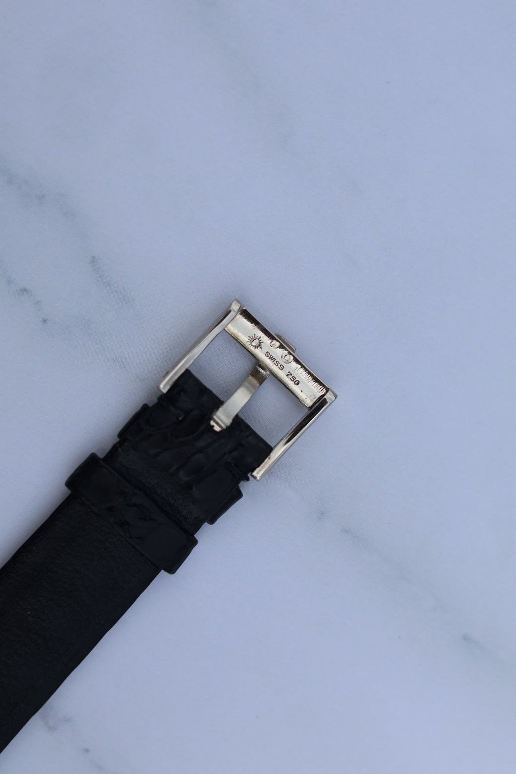Side view of Piaget-signed white gold buckle on vintage leather strap, part of Ref. 9341 watch