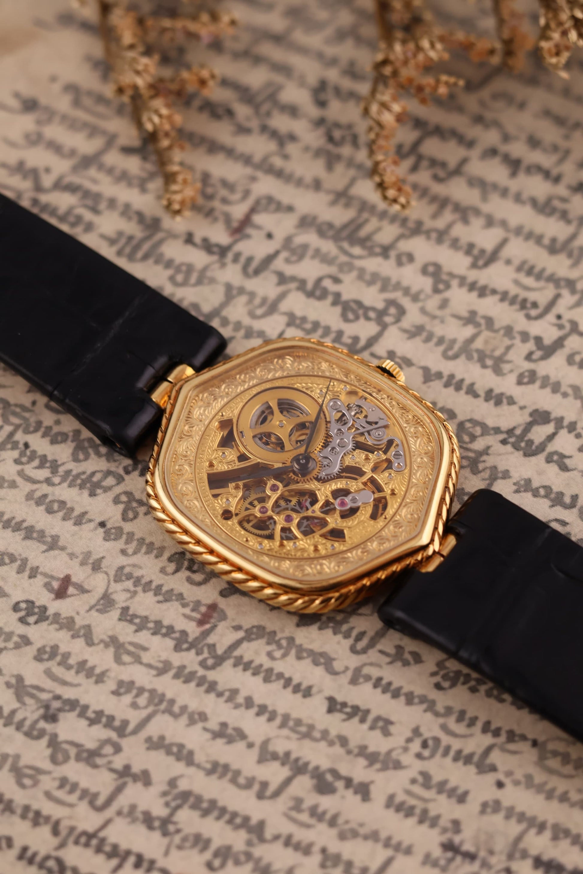 Close-up of hand-engraved 14K gold skeleton dial on Audemars Piguet watch, revealing open-worked manual movement