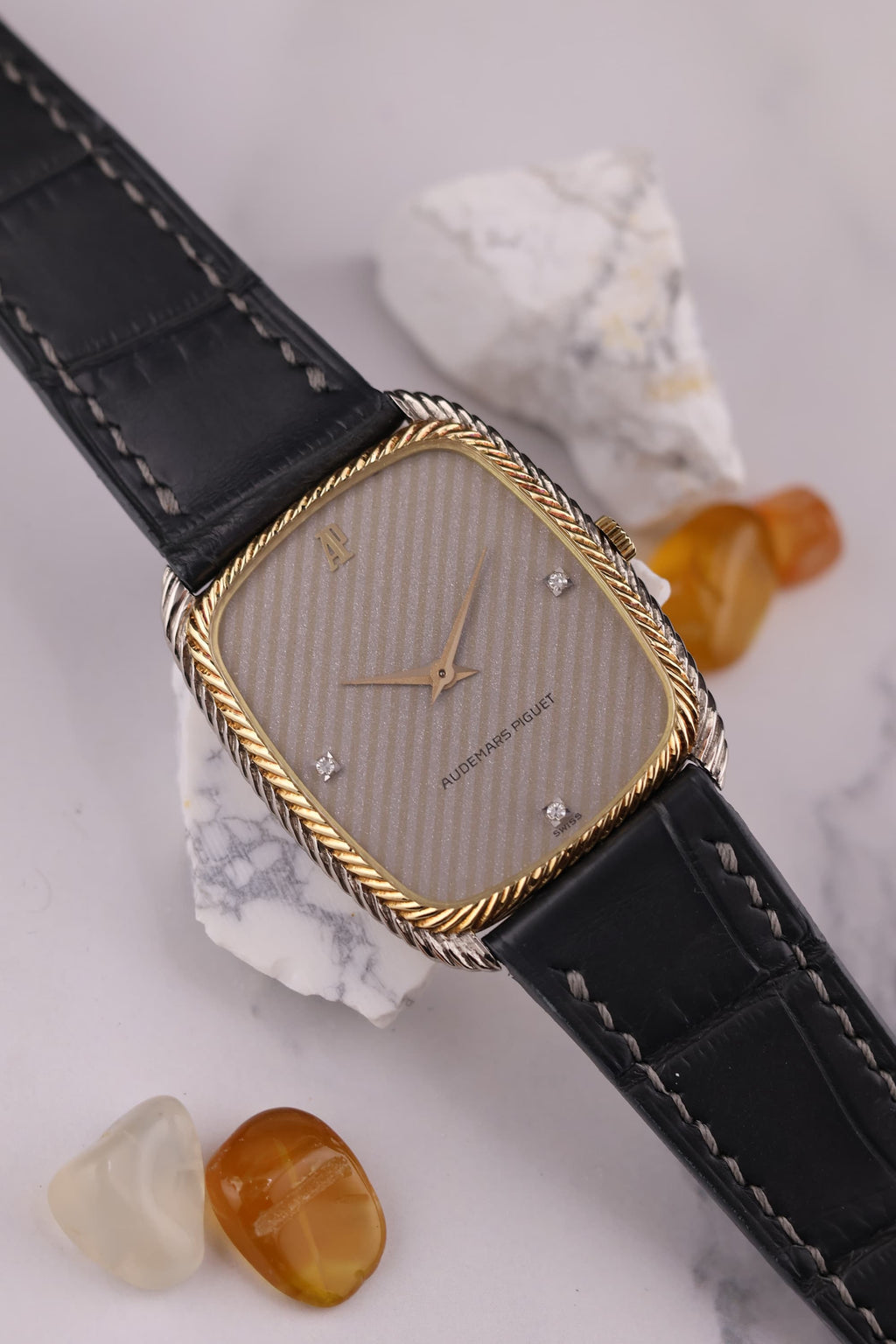 Close-up of silver dial with diagonal texture and diamond markers at 3, 6, and 9 o’clock on Audemars Piguet dress watch