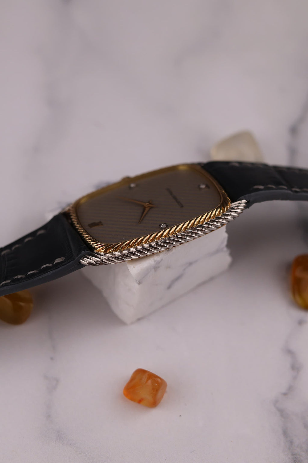 Side profile of Audemars Piguet ultra-thin watch showing slim two-tone case and braided bezel edge