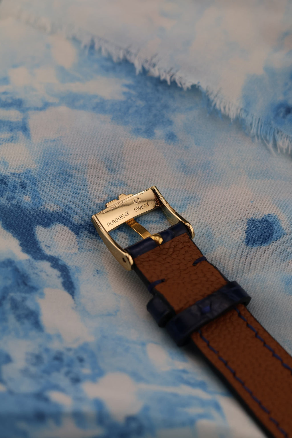 Underside view of Corum buckle in 18K gold with strap detail