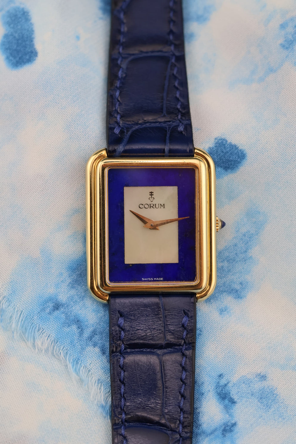 Close-up of Corum stepped bezel tank dial showcasing the luminous mother-of-pearl center and deep blue lapis lazuli surround