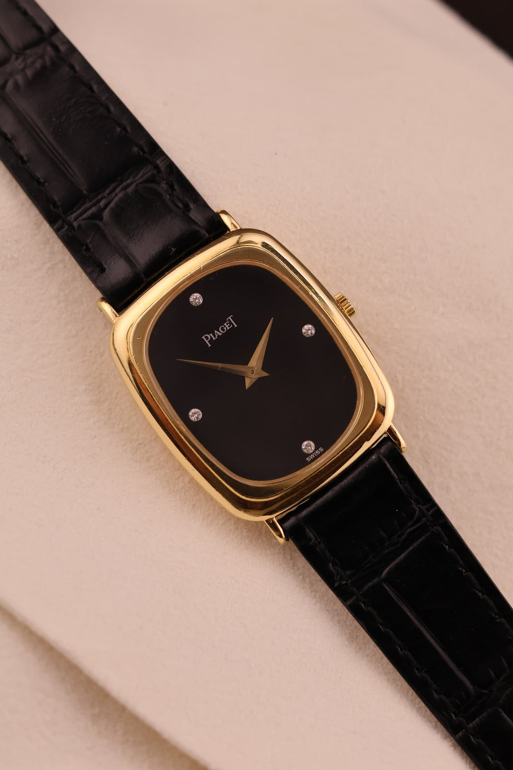 Front view of vintage Piaget dress watch with black onyx dial, diamond markers, and 18K yellow gold case.