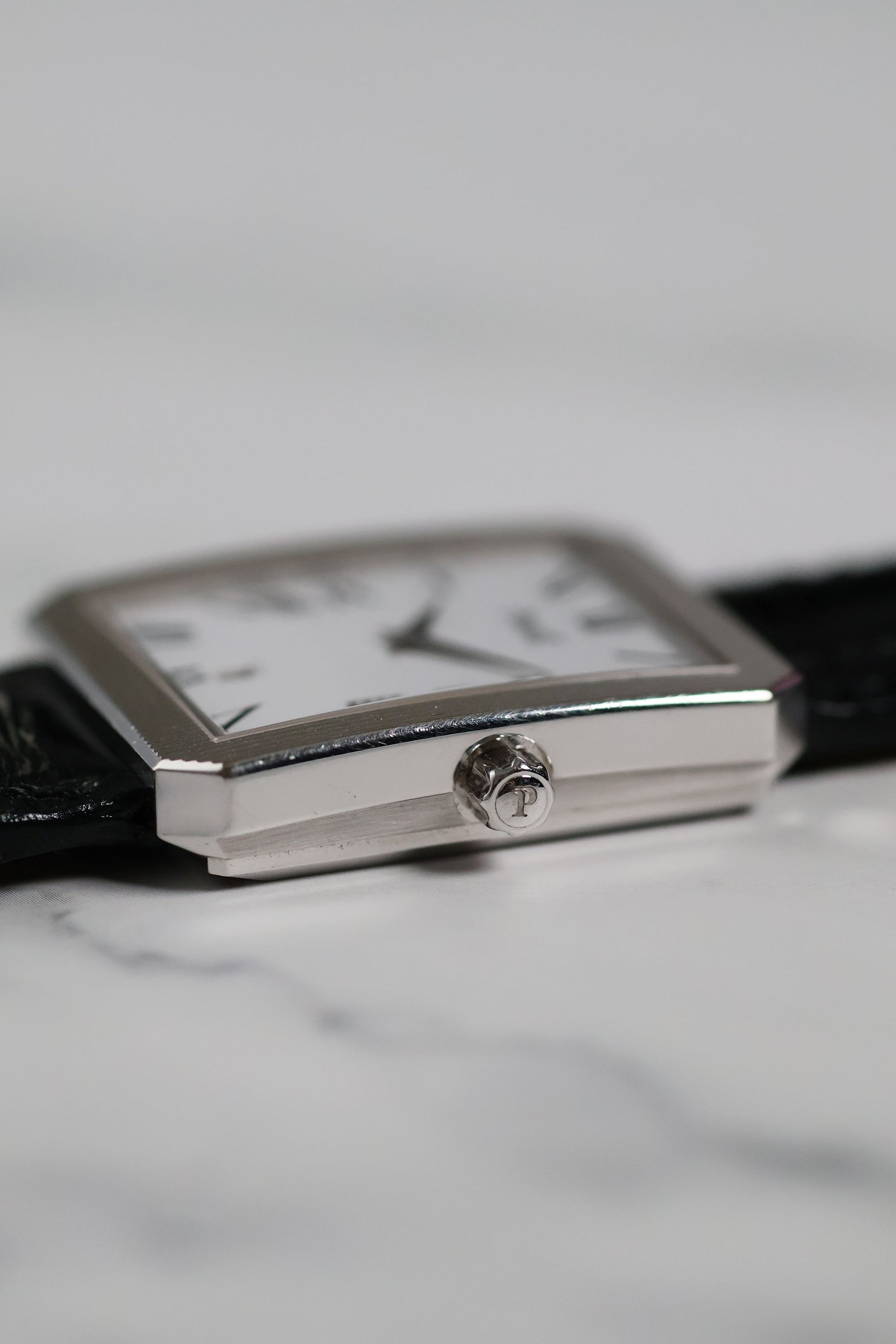 Detailed shot of Piaget Ref. 26354 signed crown with vertical fluted case edges in 18K white gold.