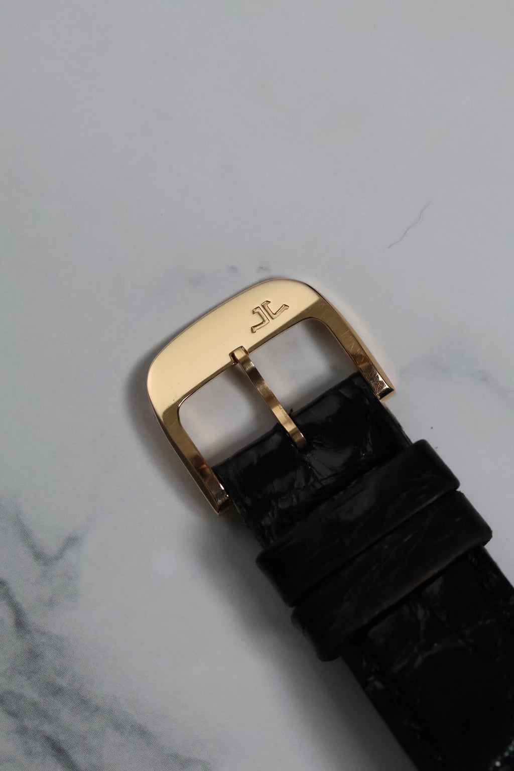 Top view of the original Jaeger-LeCoultre 18K rose gold buckle with engraved logo.