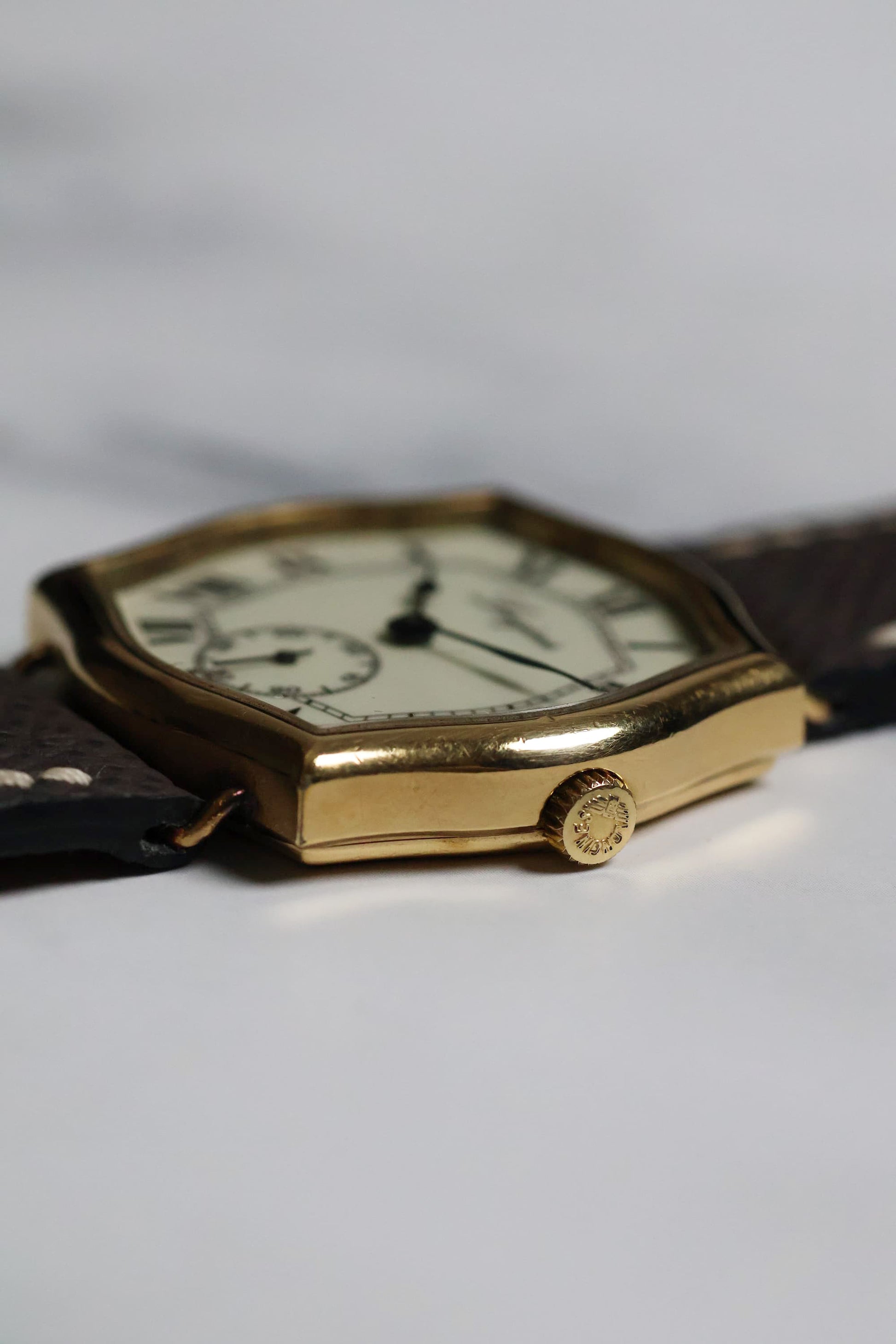 Close-up of the watch crown and case edge, highlighting the gold-plated finish and crisp transitions.