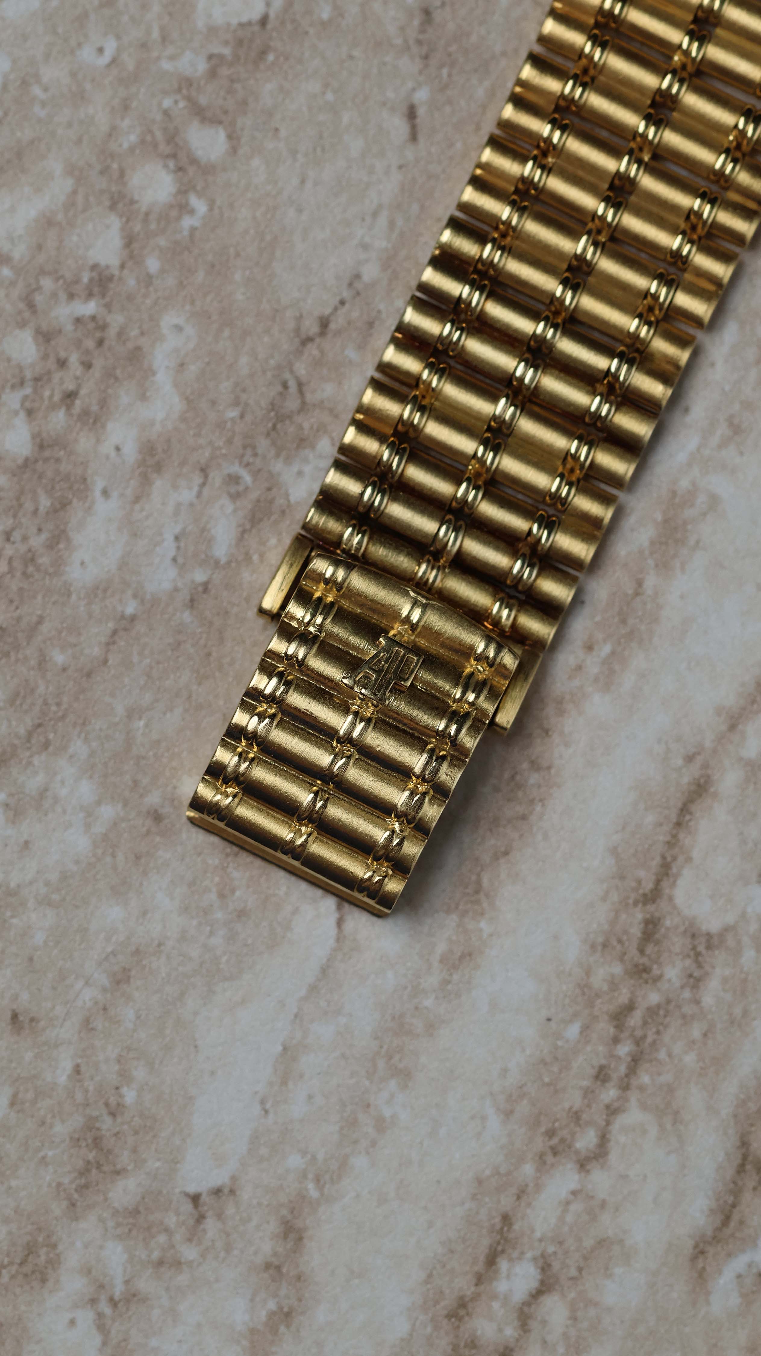 Top view of the integrated bamboo-style clasp on the Audemars Piguet 18K yellow gold bracelet.
