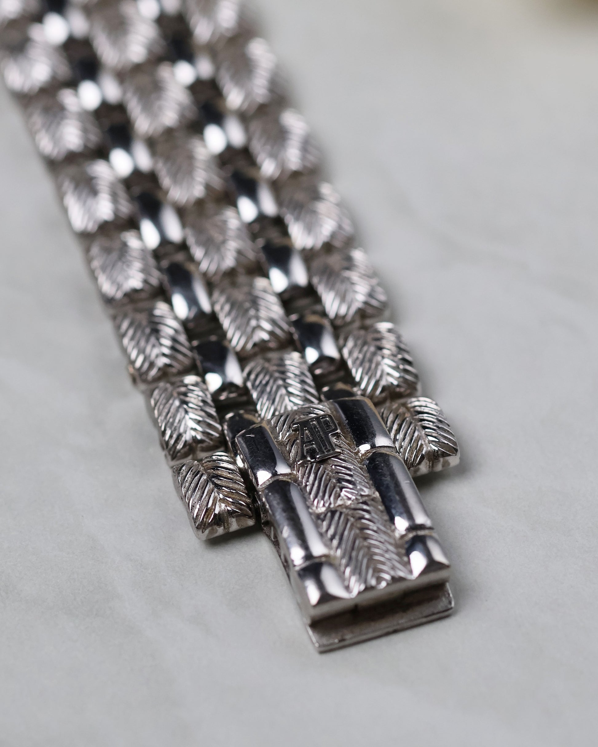 Close-up of the hidden clasp mechanism seamlessly integrated into the engraved white gold bracelet.
