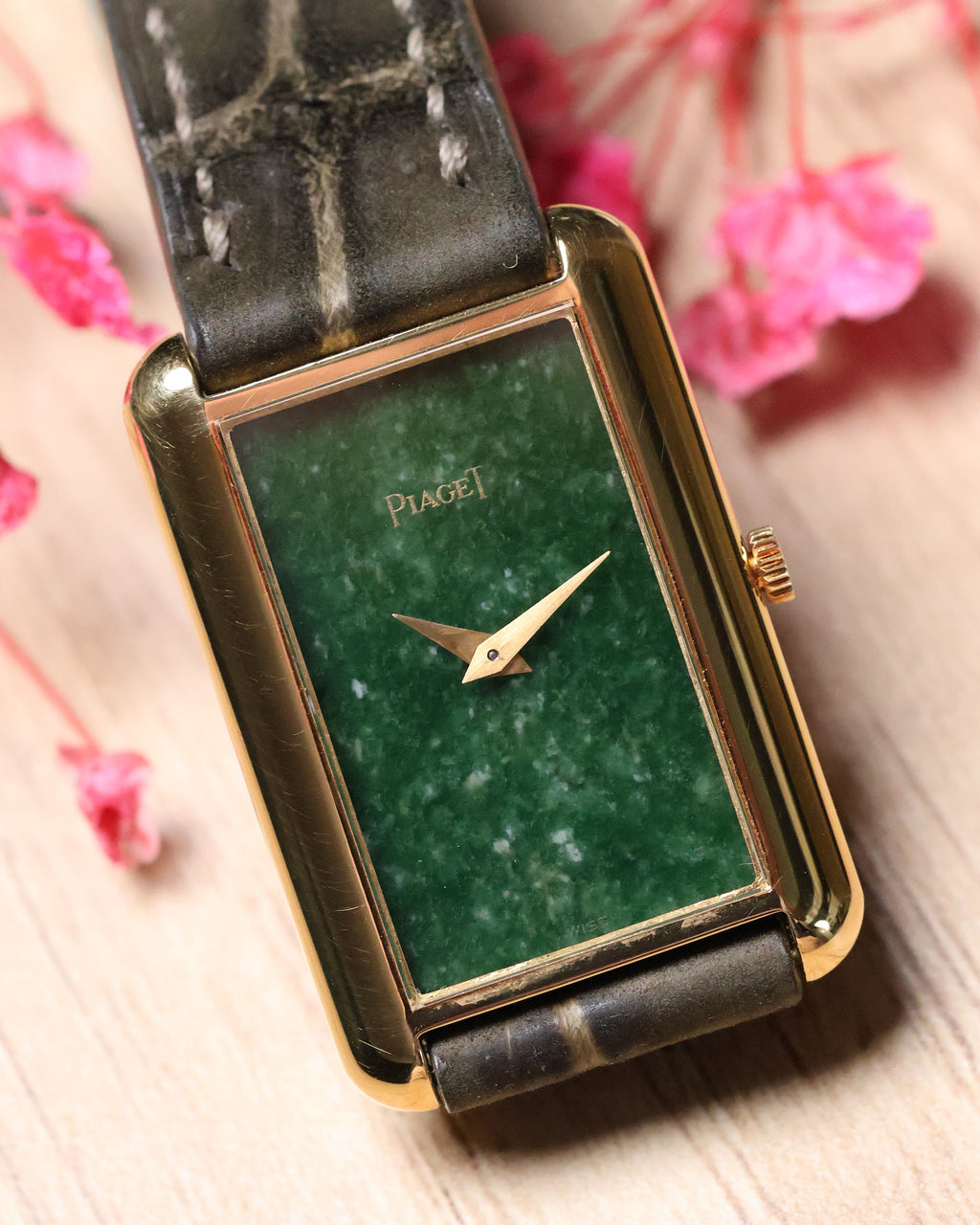 Piaget Ref. 9228 rectangular gold watch with jade stone dial, displayed on stand