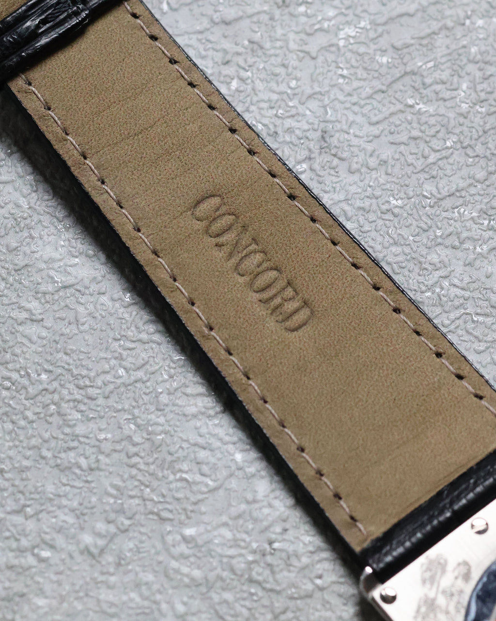 Close-up of the black alligator leather strap with Concord logo embossed on the lining.