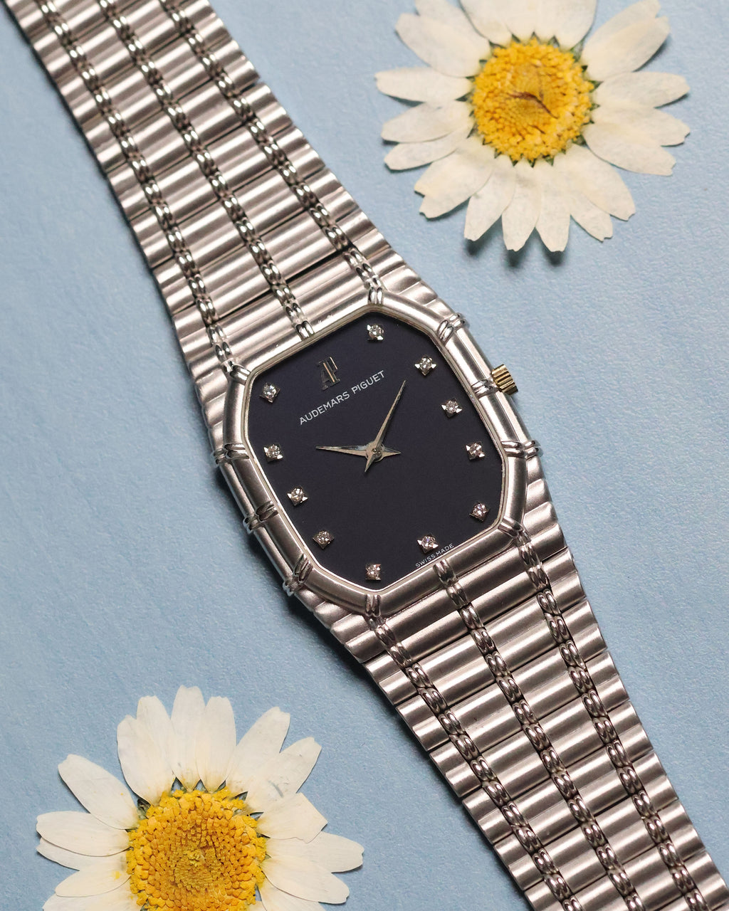 Audemars Piguet Bamboo 27mm in 18k white gold with dark blue matte dial and diamond hour markers, full view on integrated bracelet