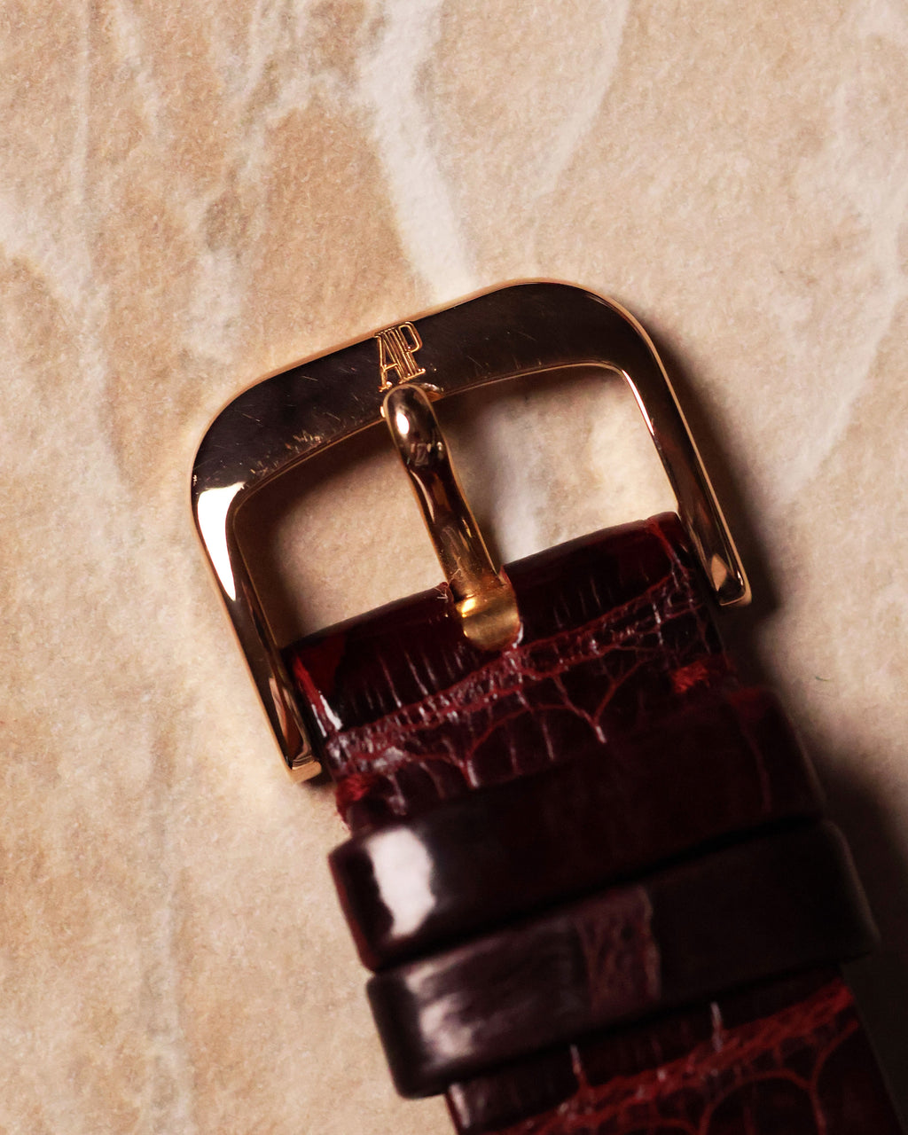 Original 18k rose gold Audemars Piguet buckle, top view, attached to leather strap