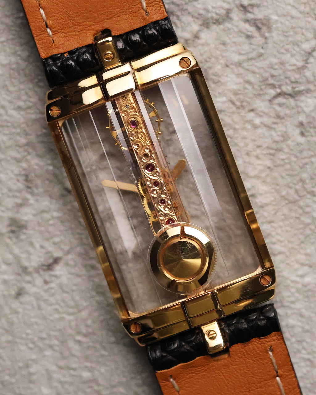Caseback view of the Corum Golden Bridge 13150, showing the sapphire transparency and the rear-mounted gold crown designed for winding, integrated seamlessly into the rectangular case.