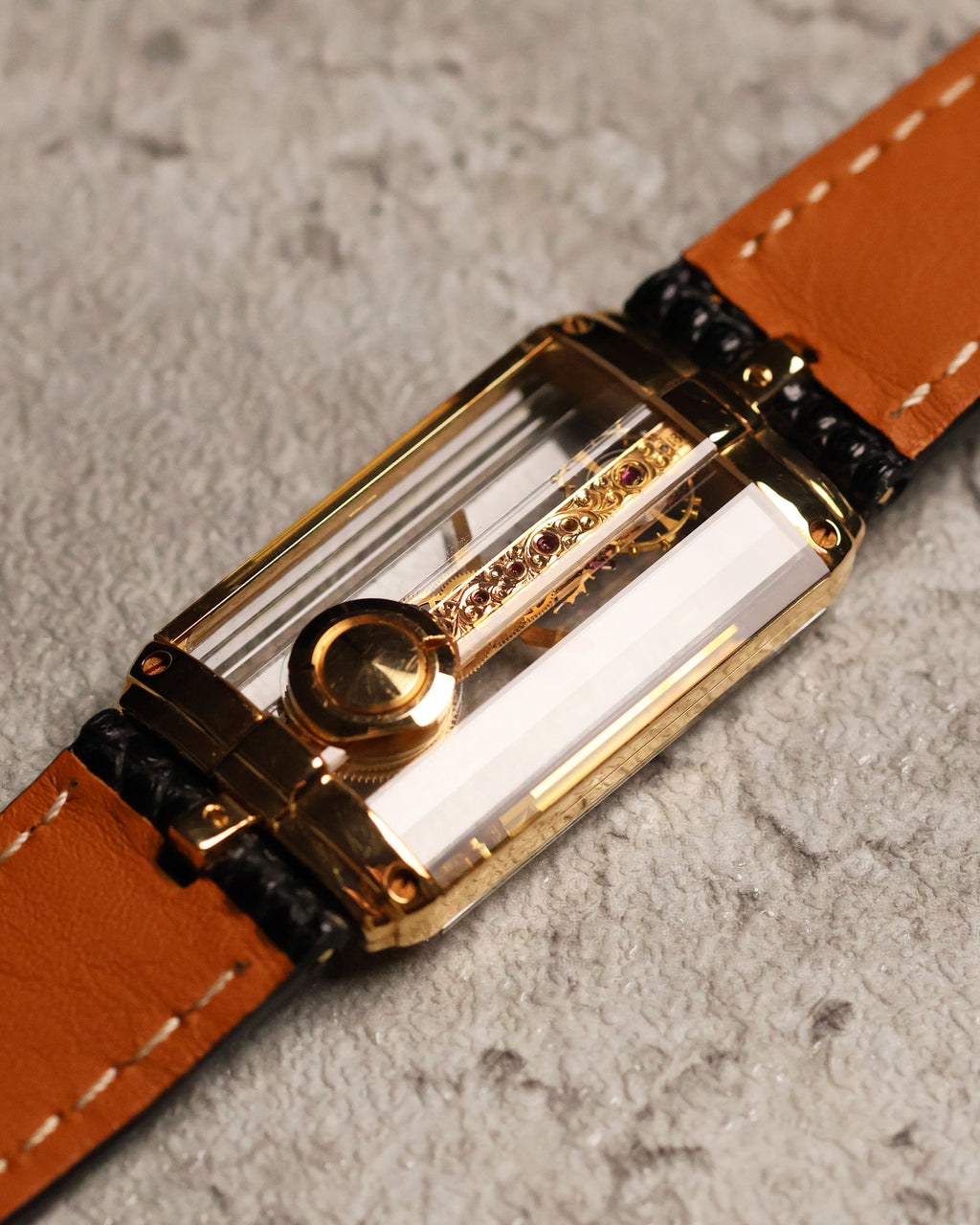 Low-angle caseback shot of the Corum Golden Bridge 13150, highlighting the back-mounted crown and gold screws securing the sapphire crystal structure.