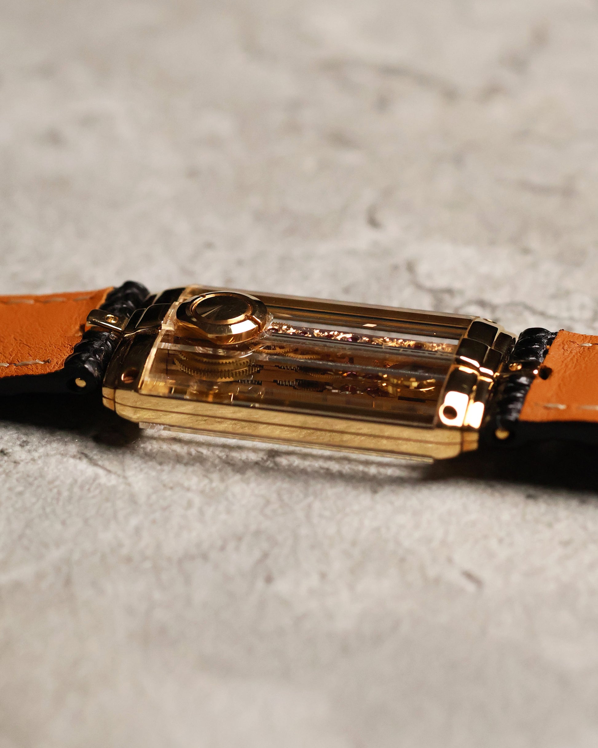 Side profile of the Corum Golden Bridge 13150, showing the slim rectangular 18k yellow gold case and the transparent sapphire construction that reveals the linear bridge movement within.