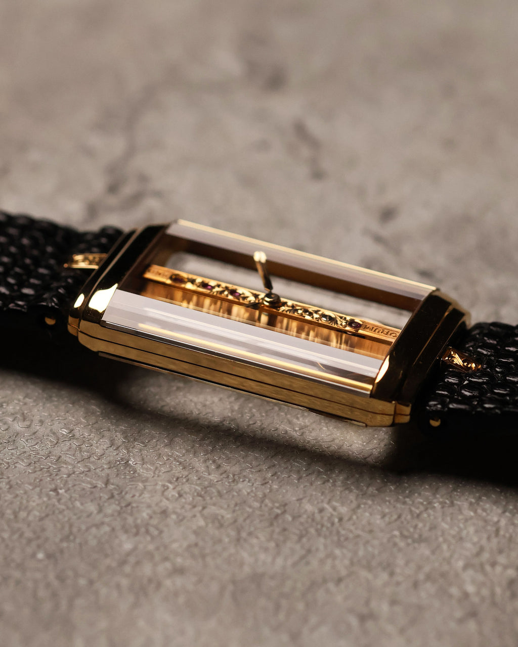 Angled wrist-side view of the Corum Golden Bridge 13150, emphasizing the floating movement inside the sapphire case and the polished gold frame.