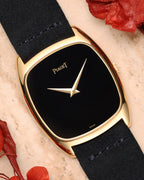 Piaget Ref. 9591 in 18k yellow gold with minimalist black lacquer dial and gold dauphine hands, cushion-shaped case.
