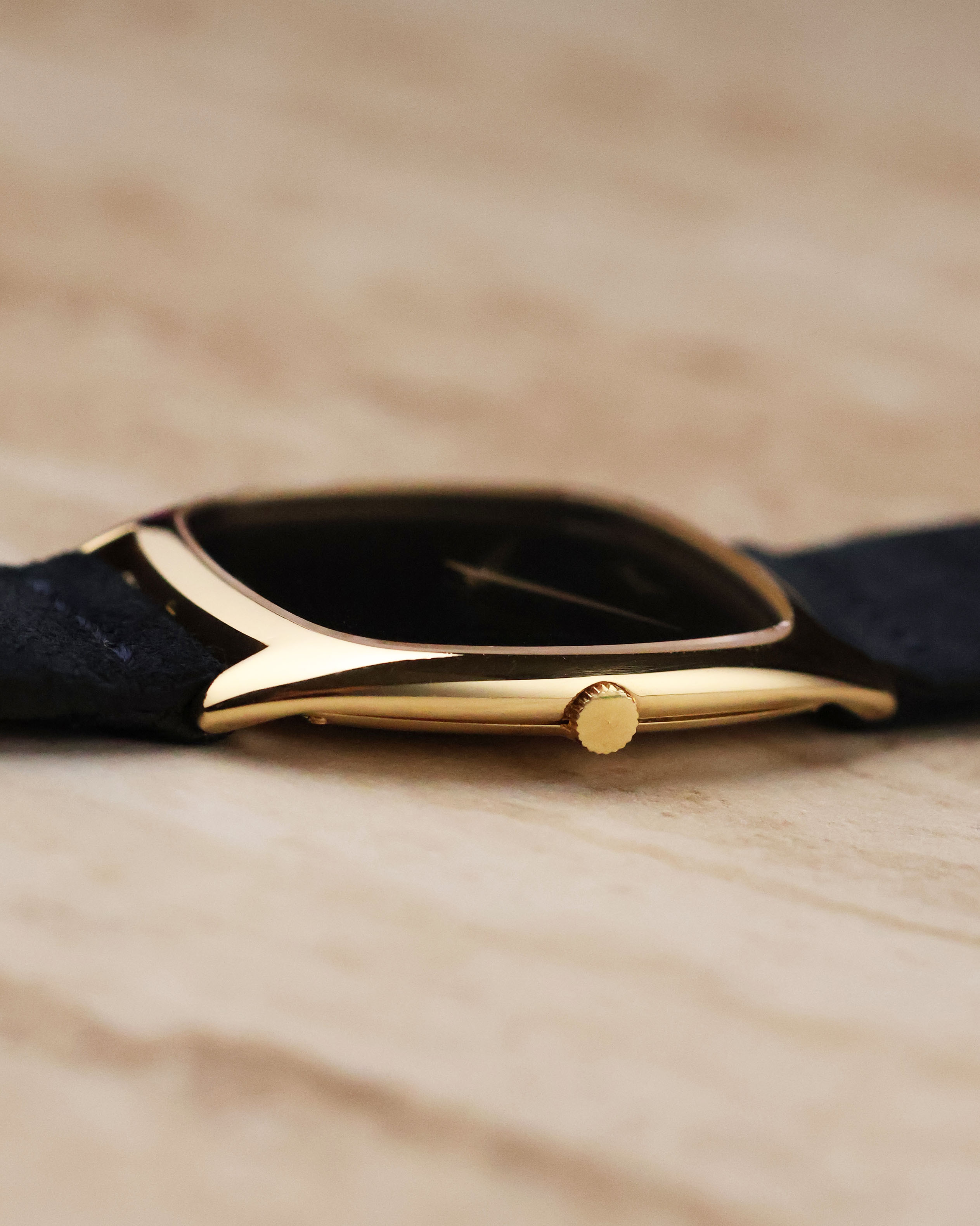 Close-up of the Piaget 9591’s small gold crown integrated into the slim cushion case profile.