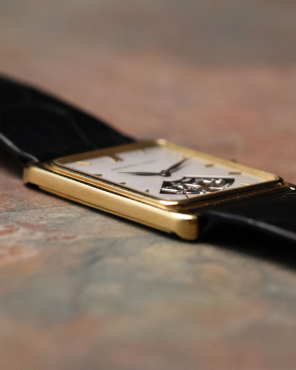 Side profile of Audemars Piguet Skeleton Aperture Tank showing slim 18K yellow gold case and curved sapphire crystal.