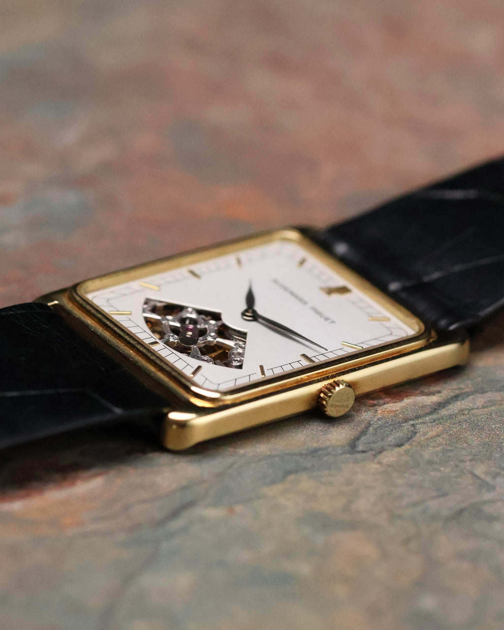 Crown-side detail of Audemars Piguet Skeleton Aperture Tank showing gold crown and bevelled rectangular case edge.