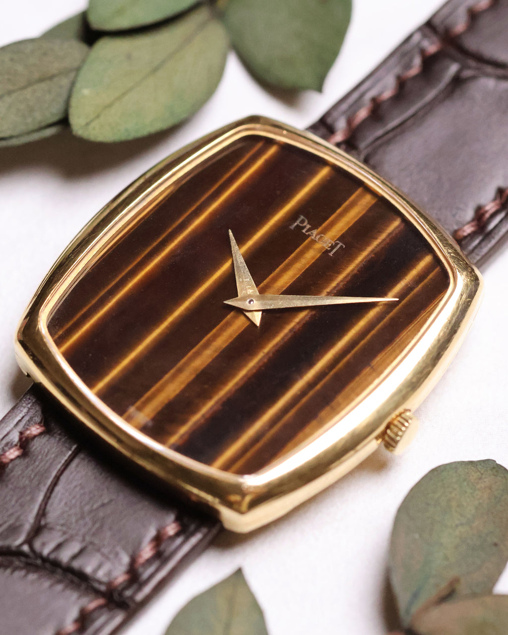 Angled shot of Piaget Ref. 9741 highlighting its vertical Tiger’s Eye stone dial and minimalist gold dauphine hands