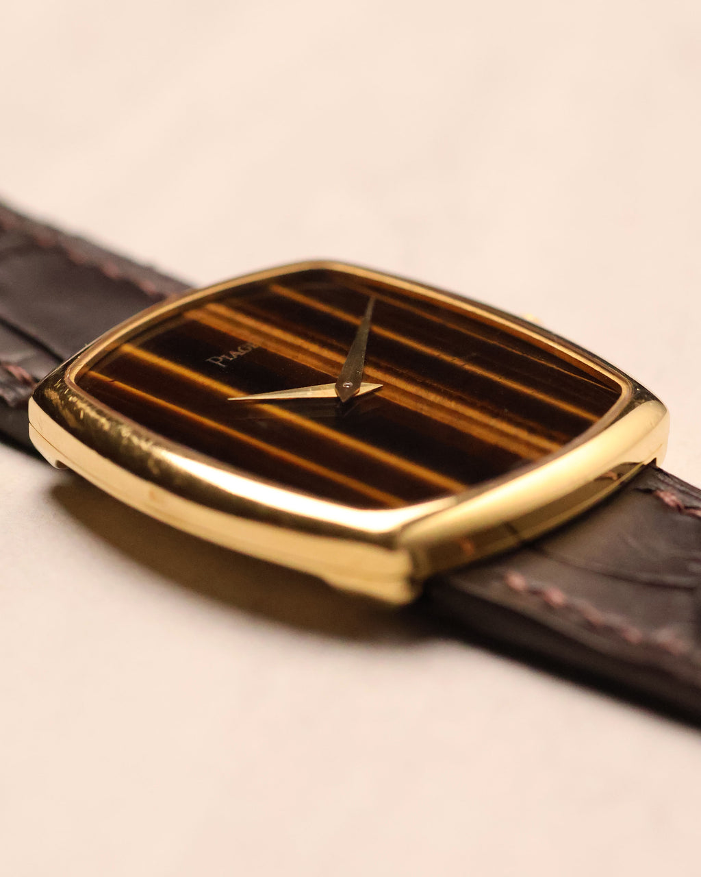 Oblique perspective of Piaget Ref. 9741 emphasizing the curvature of the gold case and the vertical Tiger’s Eye dial pattern.