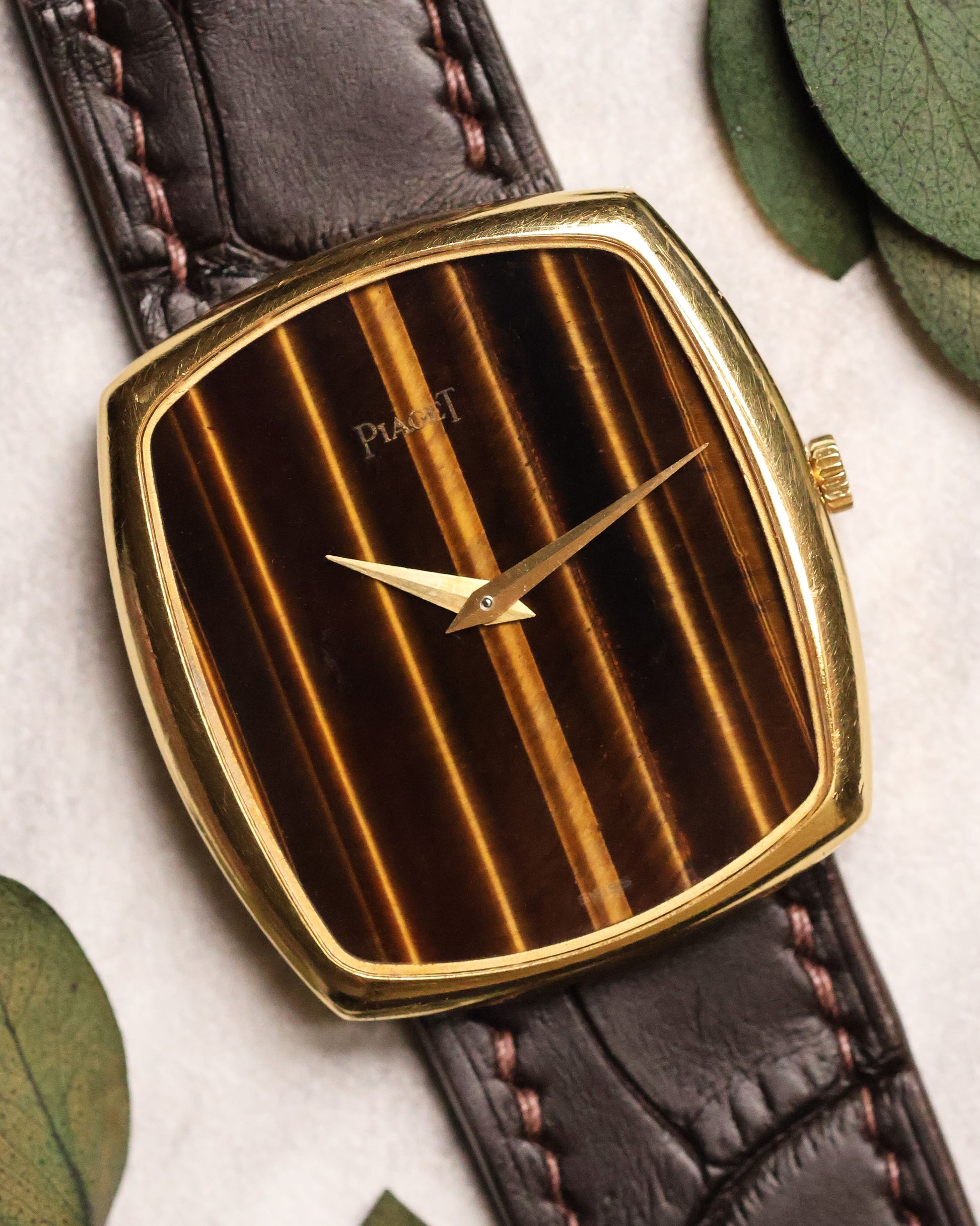 Close-up of Piaget Ref. 9741 watch featuring a vertical Tiger’s Eye dial and 18K yellow gold case, paired with a brown leather strap.
