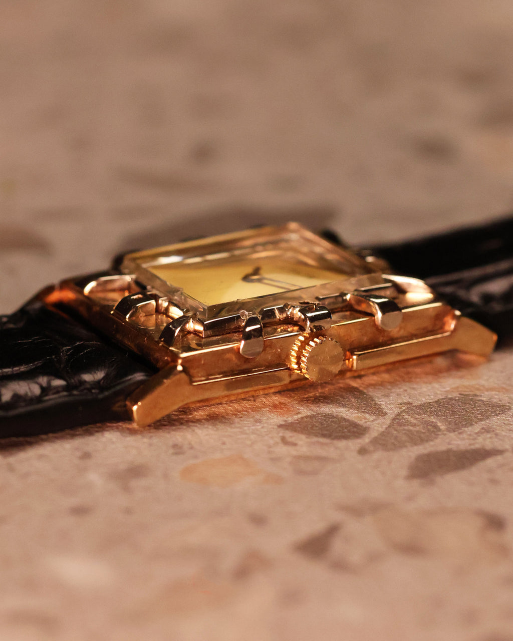 Side profile of the LeCoultre 14K gold Art Deco watch highlighting the stepped bezel design and manual-wind crown.