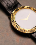 Side angle of the Piaget 9118 featuring the hand-engraved 18K gold bezel and blue lapis dial, photographed on a textured stone surface.