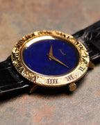Low-angle shot of the Piaget 9118 showing the engraved Roman bezel and lapis stone dial, with the black leather strap partially visible.