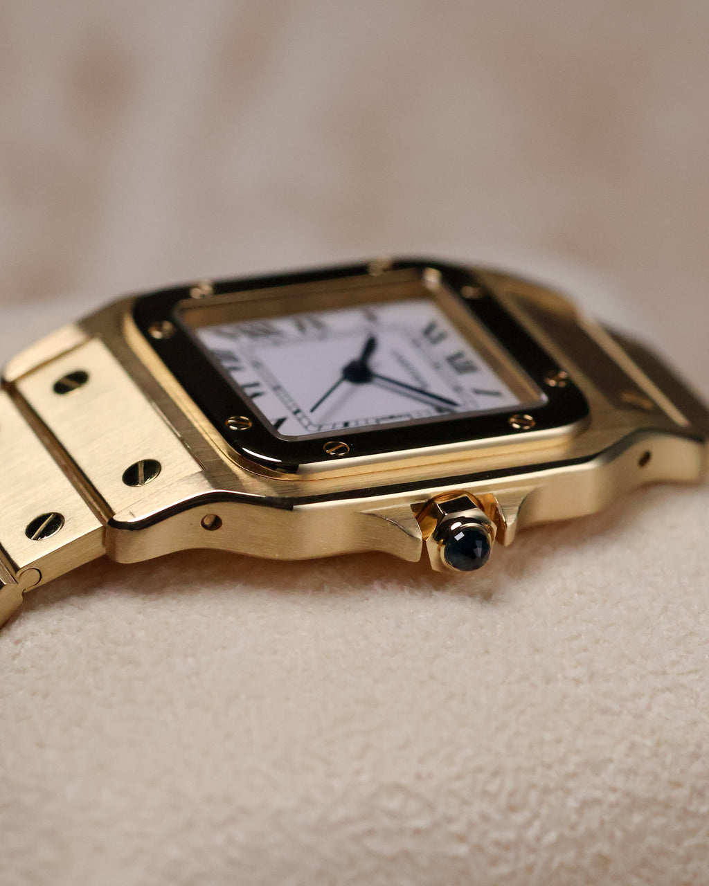 Close-up of the right side of the Cartier Santos Carrée Ref. 2960, focusing on the gold crown set with a blue cabochon.