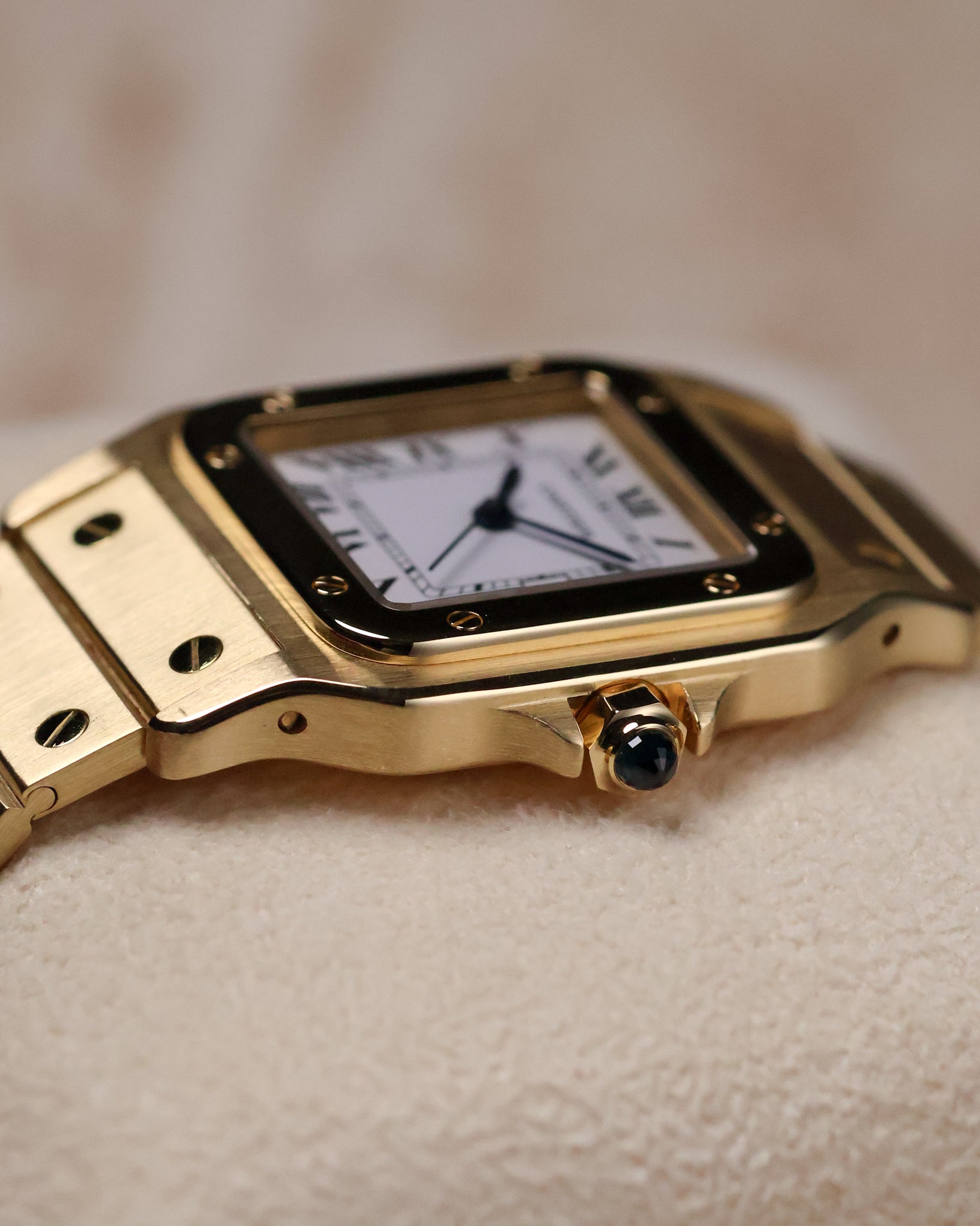 Close-up of the right side of the Cartier Santos Carrée Ref. 2960, focusing on the gold crown set with a blue cabochon.