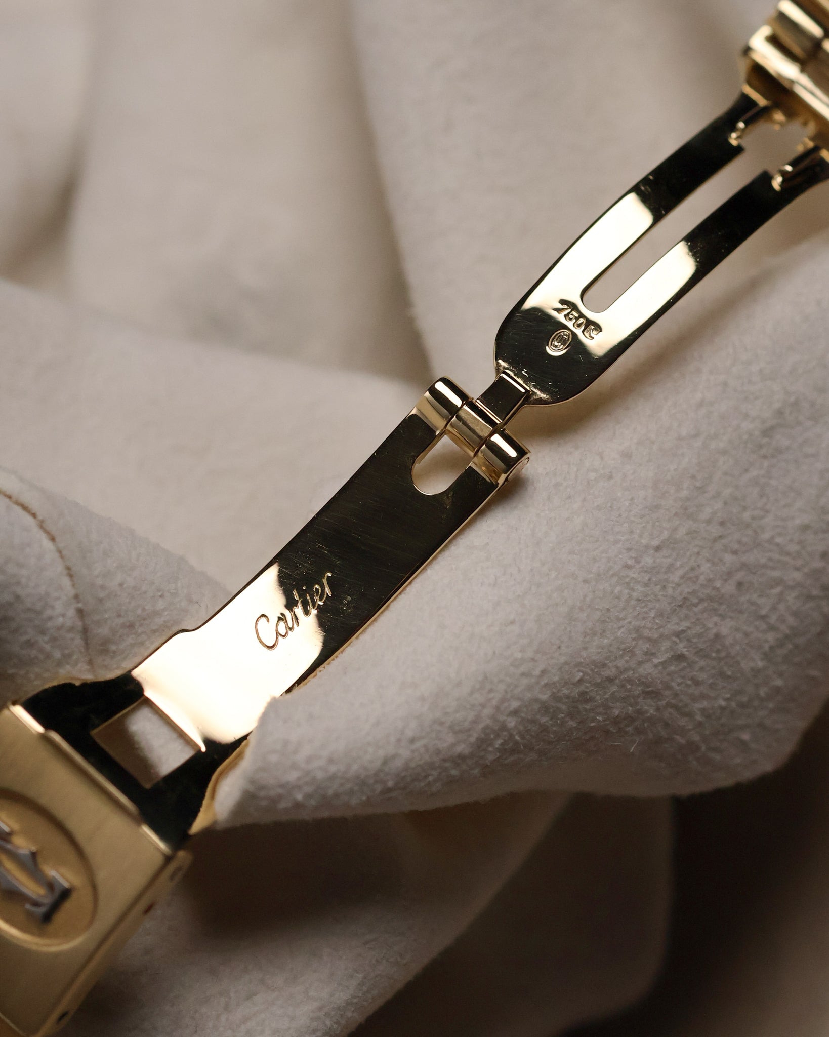 Interior view of the Cartier Santos Carrée folding clasp, displaying the polished gold components with Cartier engraving and hallmarks.