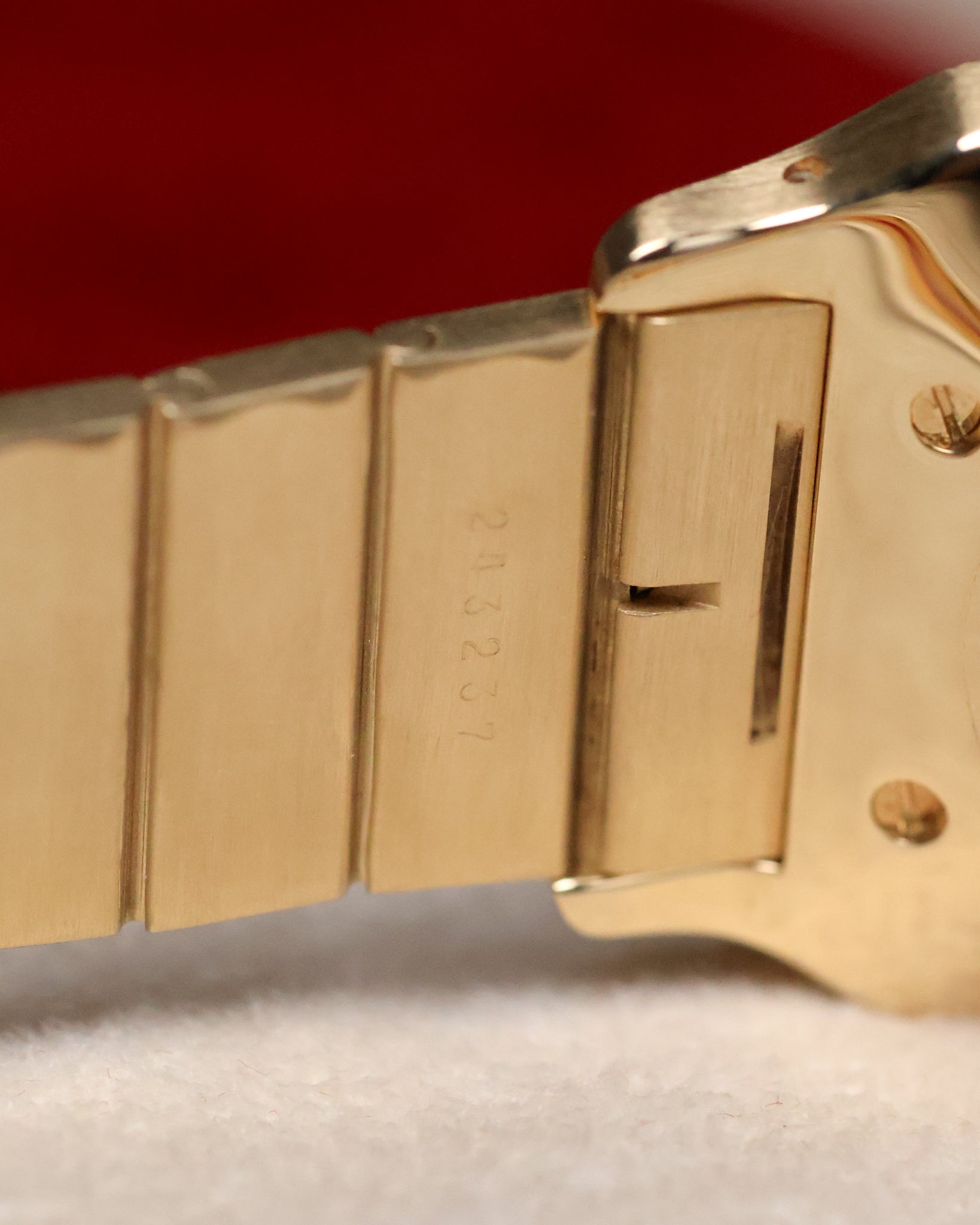 Close-up of the inner bracelet links near the clasp of the Cartier Santos Carrée, showing the engraved serial number on the 18K gold link.
