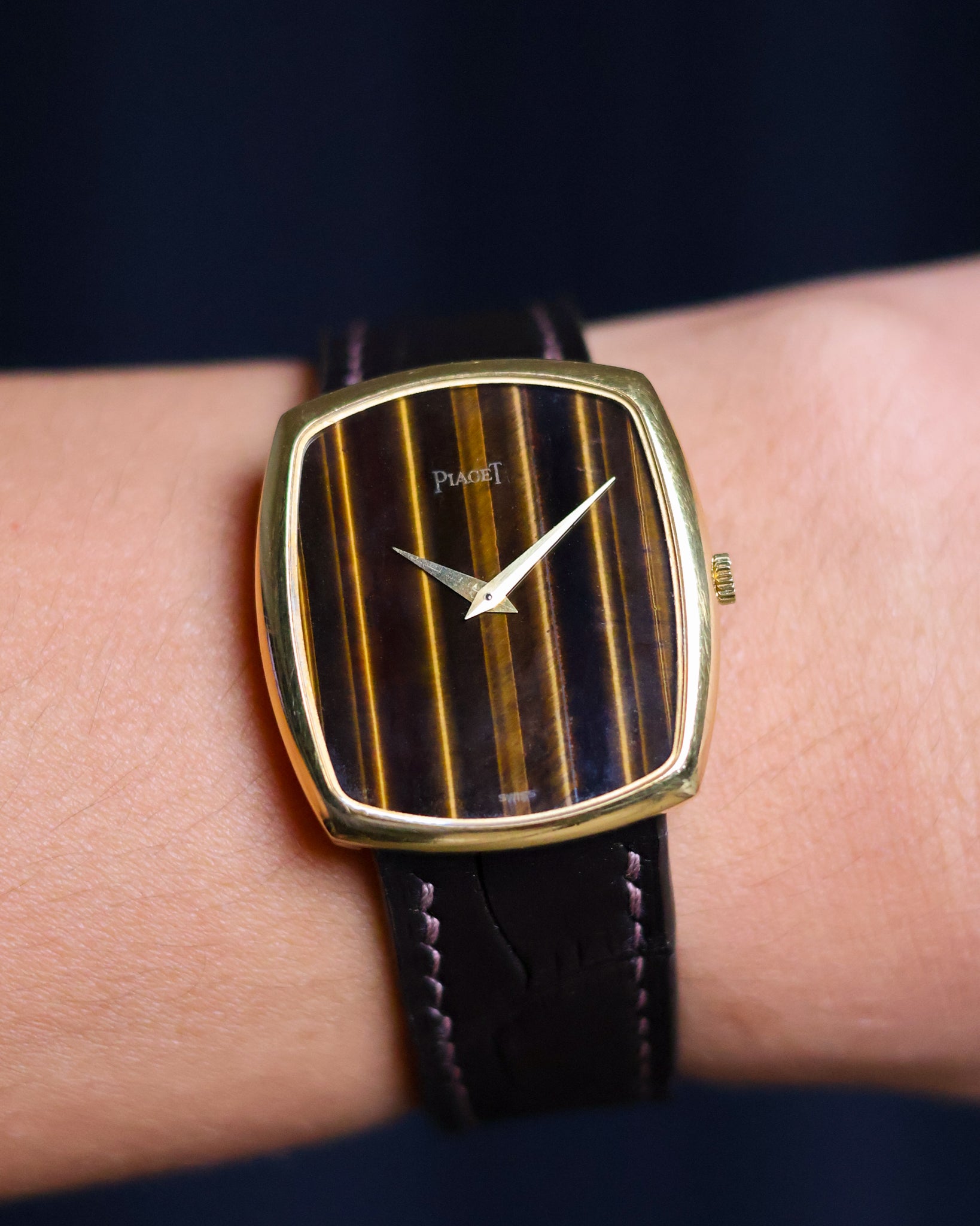 Wrist shot of Piaget Ref. 9741 watch featuring a vertical Tiger’s Eye dial and 18K yellow gold case