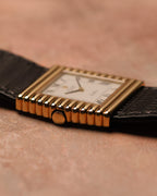 Low side-profile photograph of a Rolex Cellini Ref. 4015 highlighting the stepped ribbed gold case, gold crown, and slim dress-watch proportions.