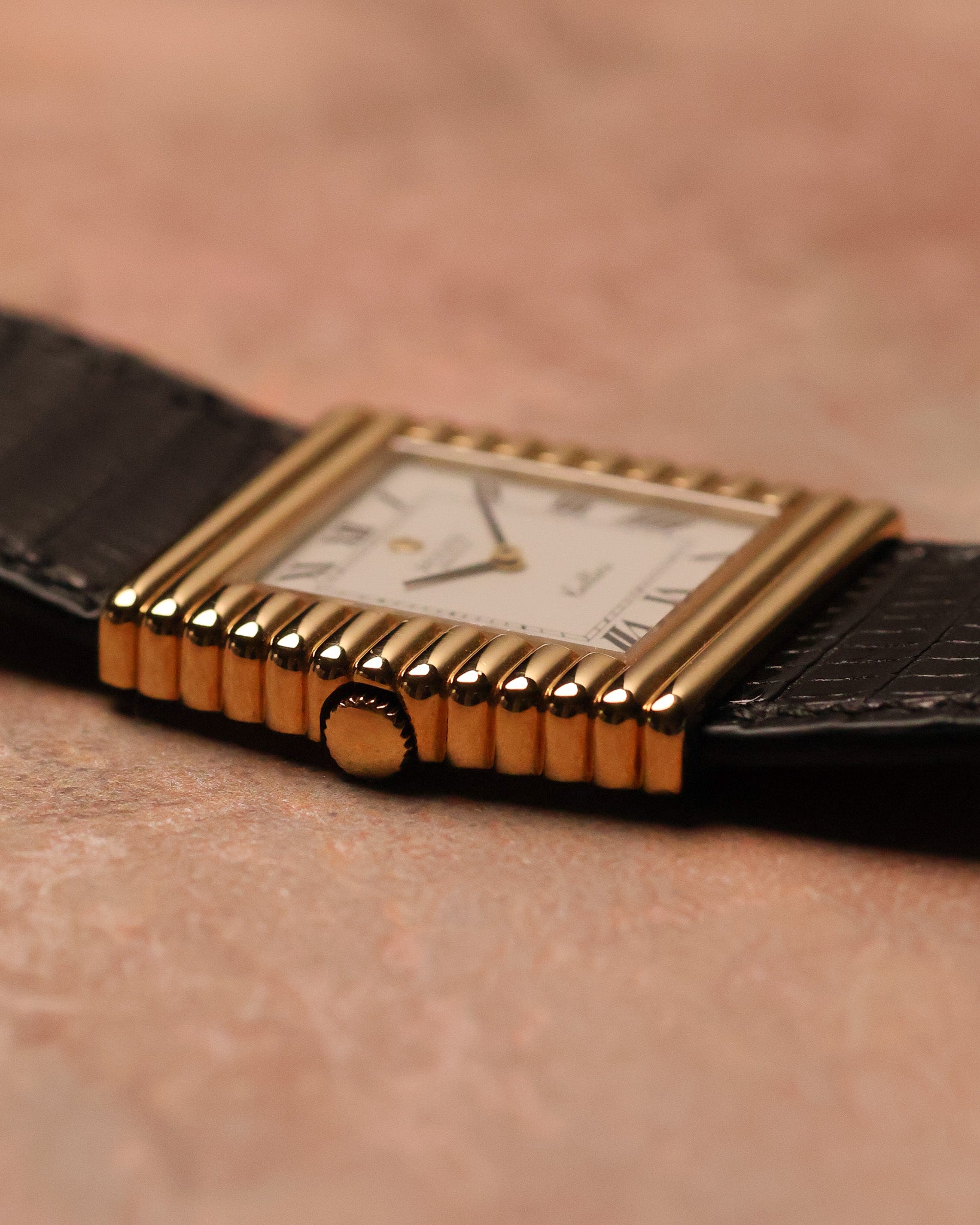 Low side-profile photograph of a Rolex Cellini Ref. 4015 highlighting the stepped ribbed gold case, gold crown, and slim dress-watch proportions.