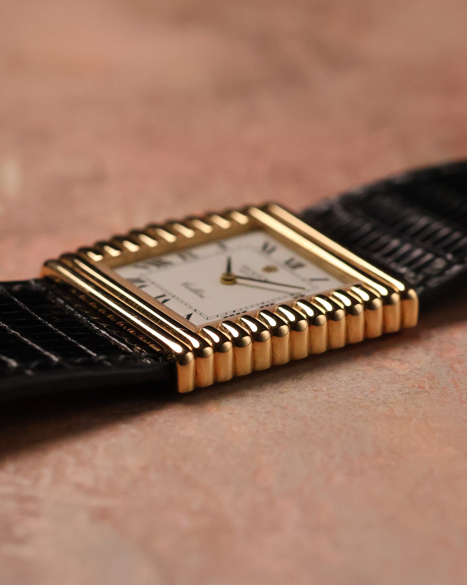 Angled side view of the Rolex Cellini Ref. 4015 showing the asymmetric gold case shape, fluted sides, and ivory Roman numeral dial.