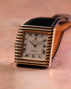 Upright angled view of the Rolex Cellini Ref. 4015 with its sculptural asymmetric gold case, Roman numeral dial, and black leather strap.