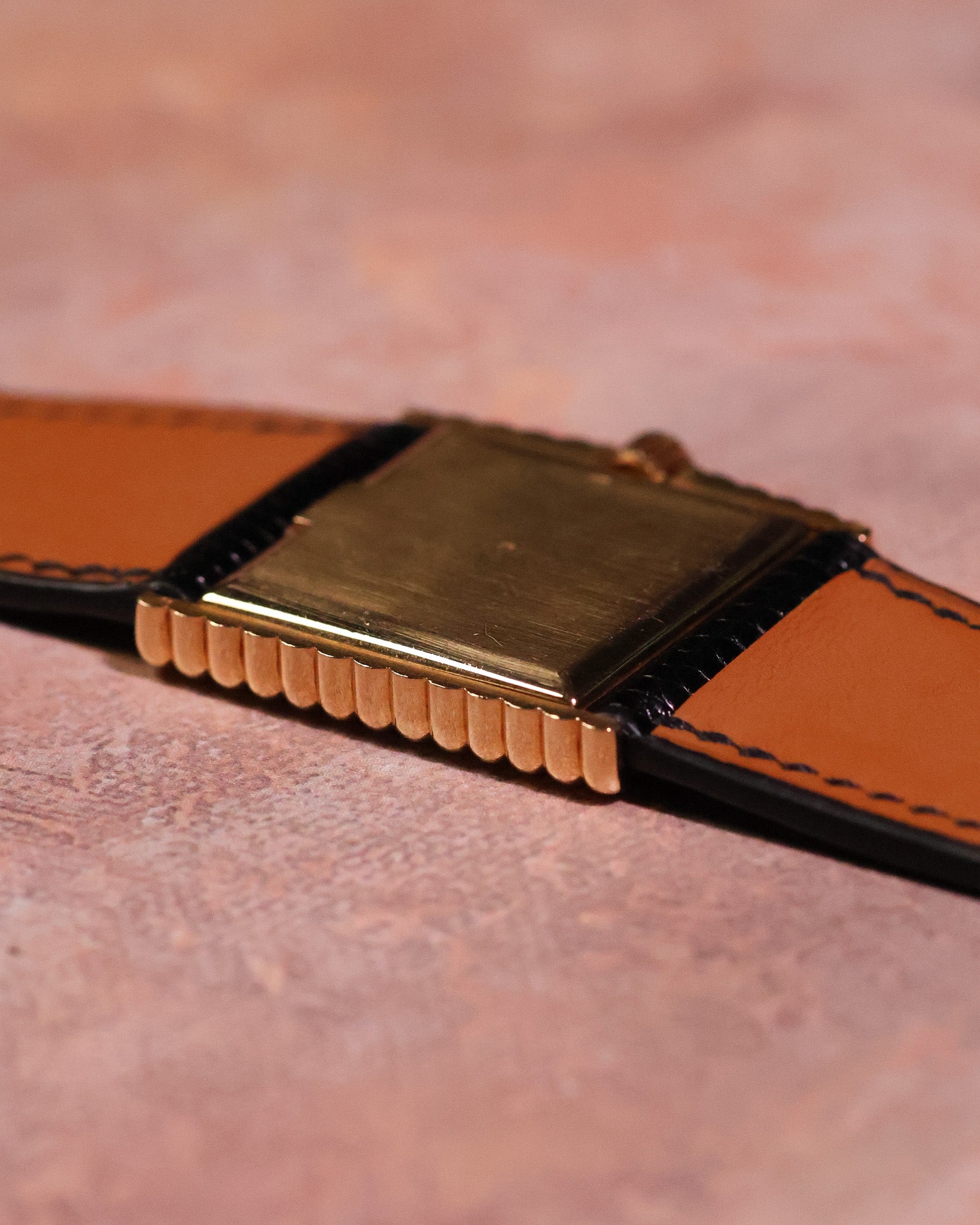 Side angle photograph of the Rolex Cellini Ref. 4015 showing the solid 18K gold caseback, ribbed case edges, and leather strap interior.