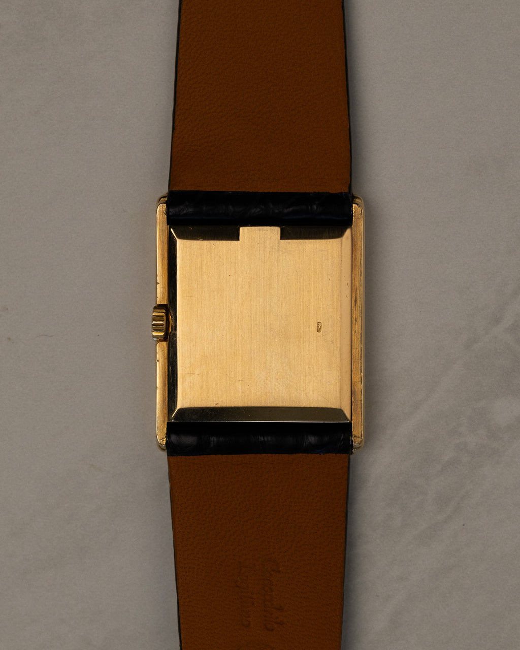 Caseback view of Rolex Cellini 4016 showing polished 18K yellow gold caseback with faint Rolex coronet and serial visible at angles