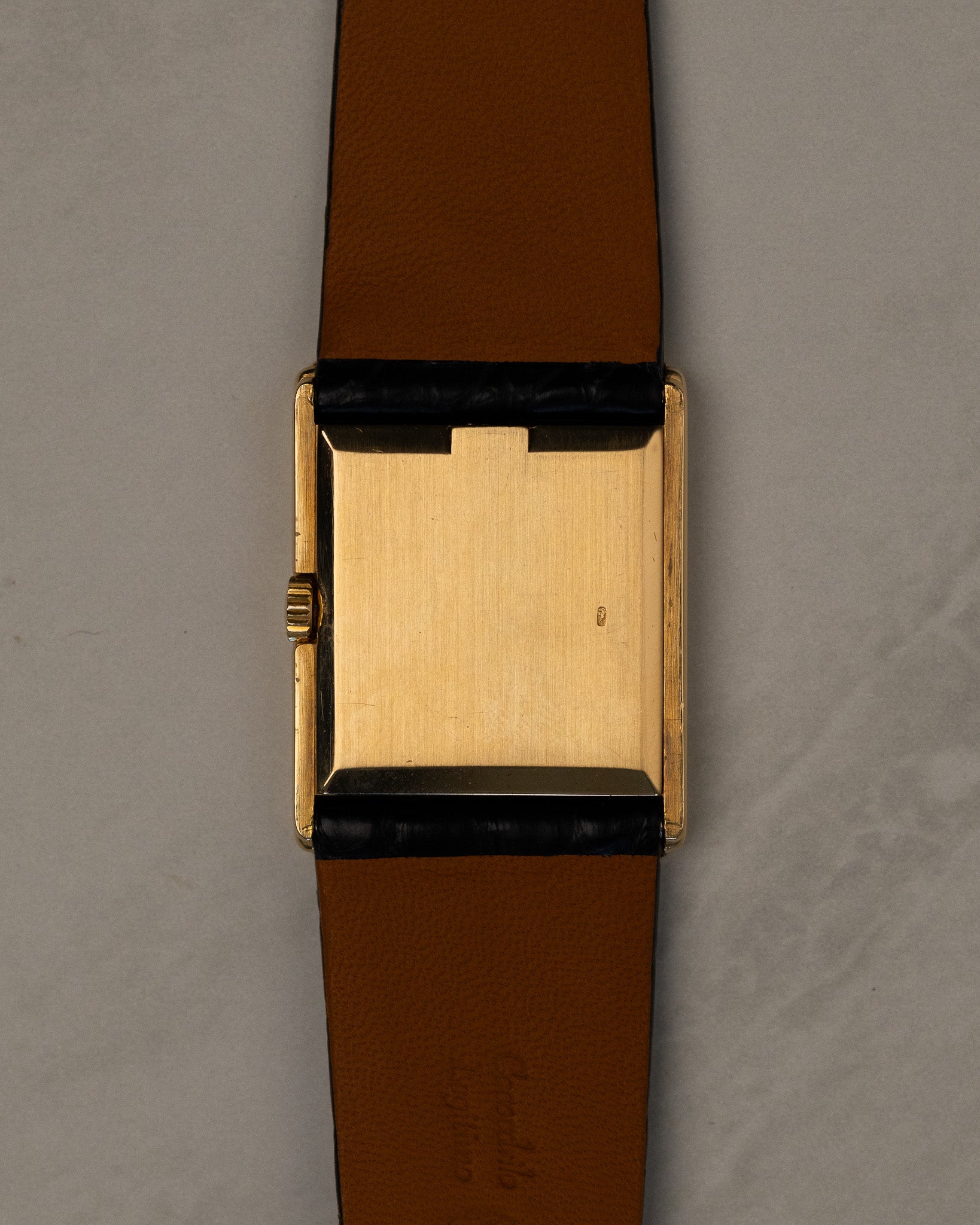 Caseback view of Rolex Cellini 4016 showing polished 18K yellow gold caseback with faint Rolex coronet and serial visible at angles