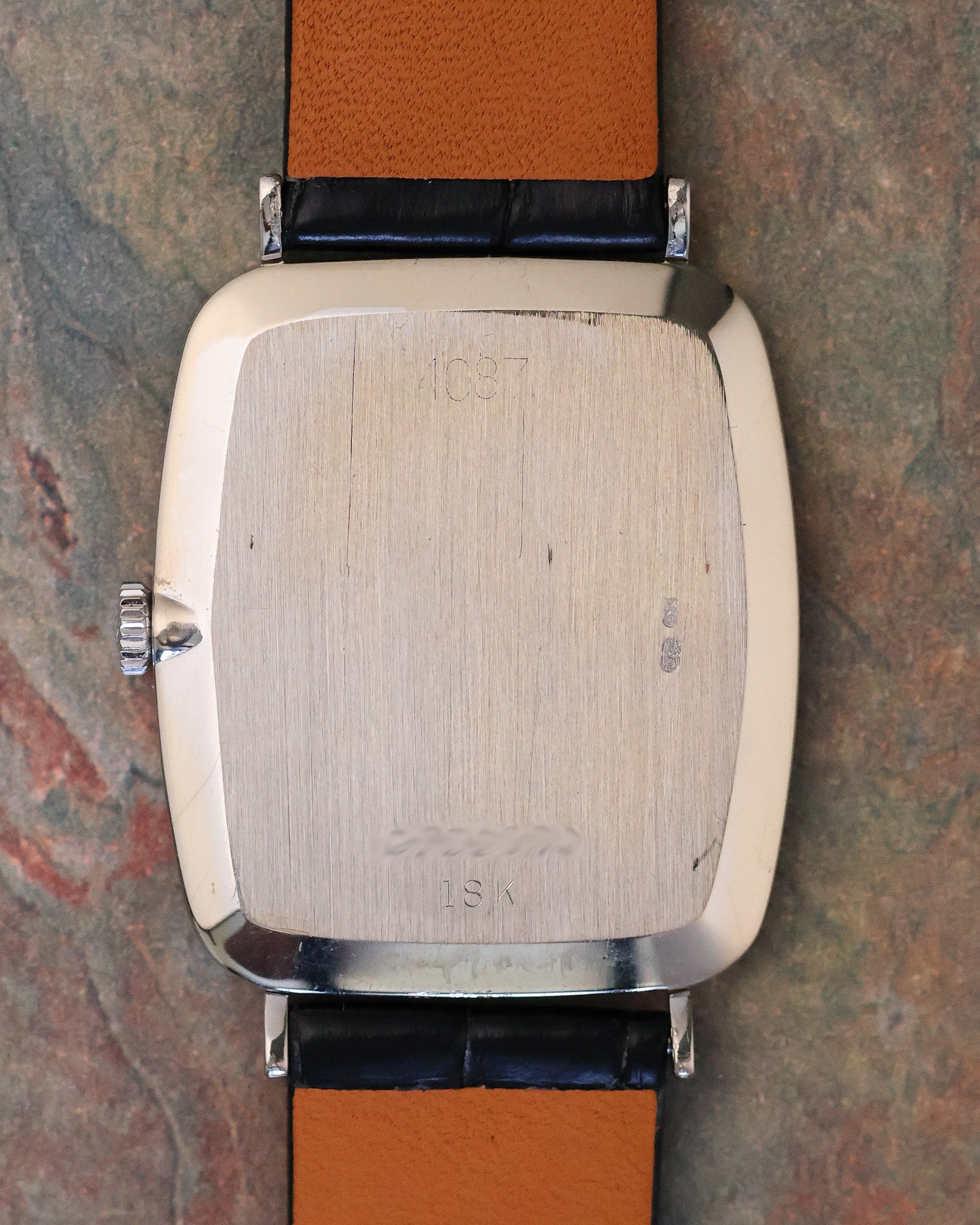 Caseback of Rolex Cellini Ref. 4087 in 18K white gold, displaying engraved reference number and gold hallmarks on brushed finish.