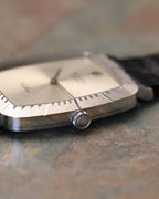 Macro side detail of Rolex Cellini crown with Rolex coronet engraving and fluted edge, set against brushed white gold case.