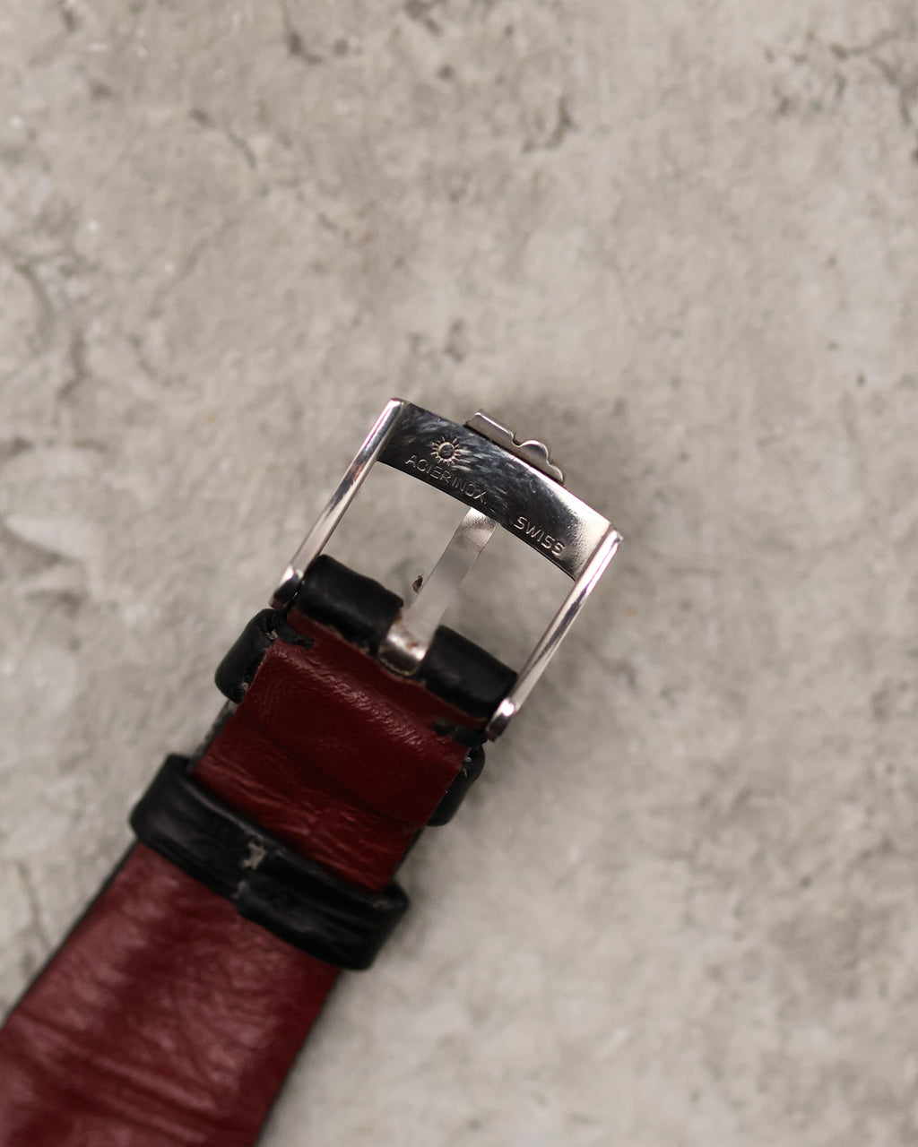 Underside of original Corum steel buckle with Corum branding and Swiss marking.
