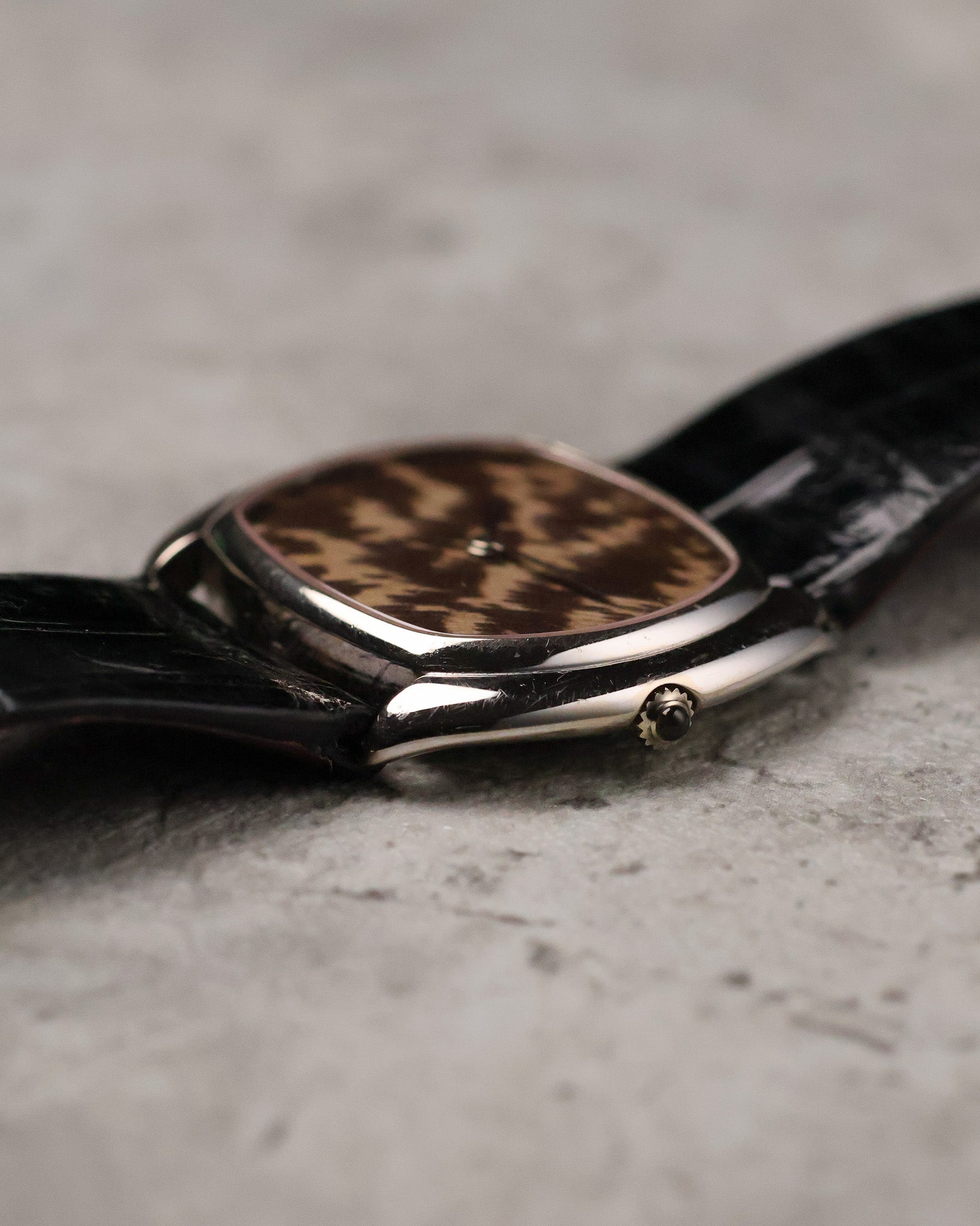 Crown-side profile of Corum white gold case highlighting polished surfaces and thin case construction.
