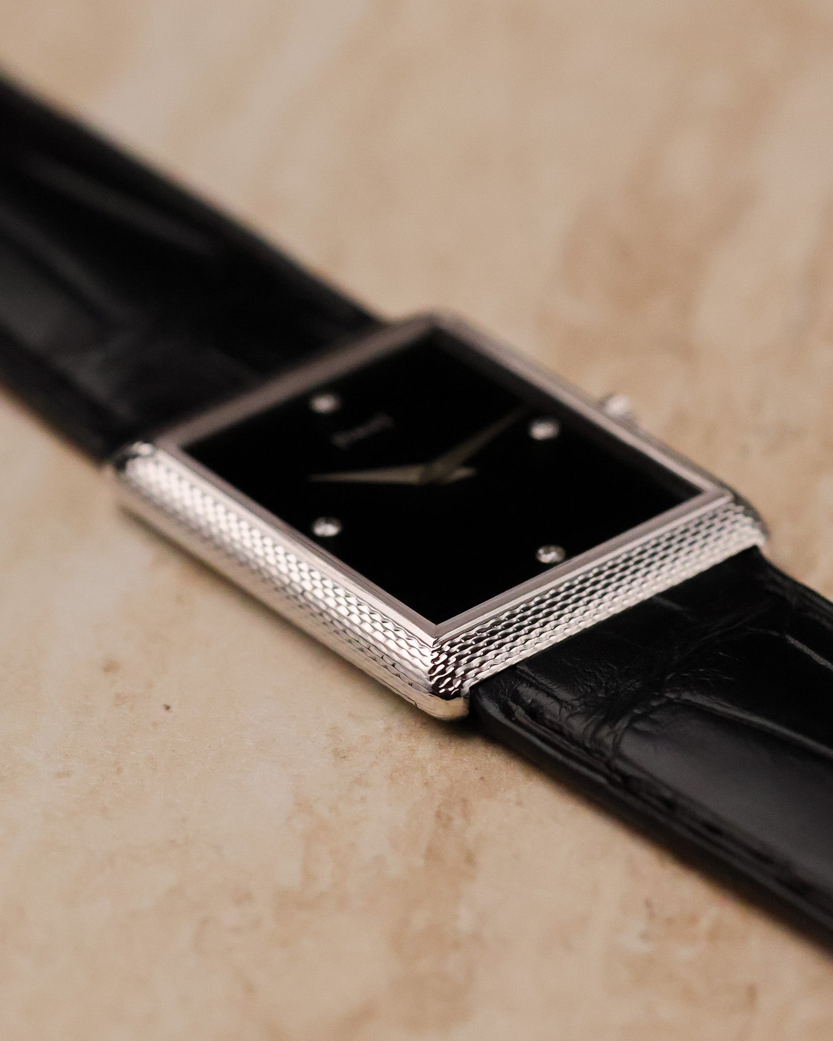 Low side profile of Piaget 9152 emphasizing slim rectangular case and woven white gold texture along the bezel edge.