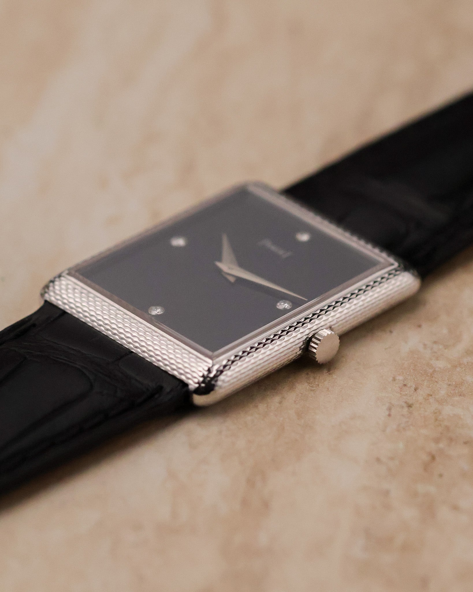 Angled side perspective showing woven 18K white gold case texture and signed crown on Piaget 9152.