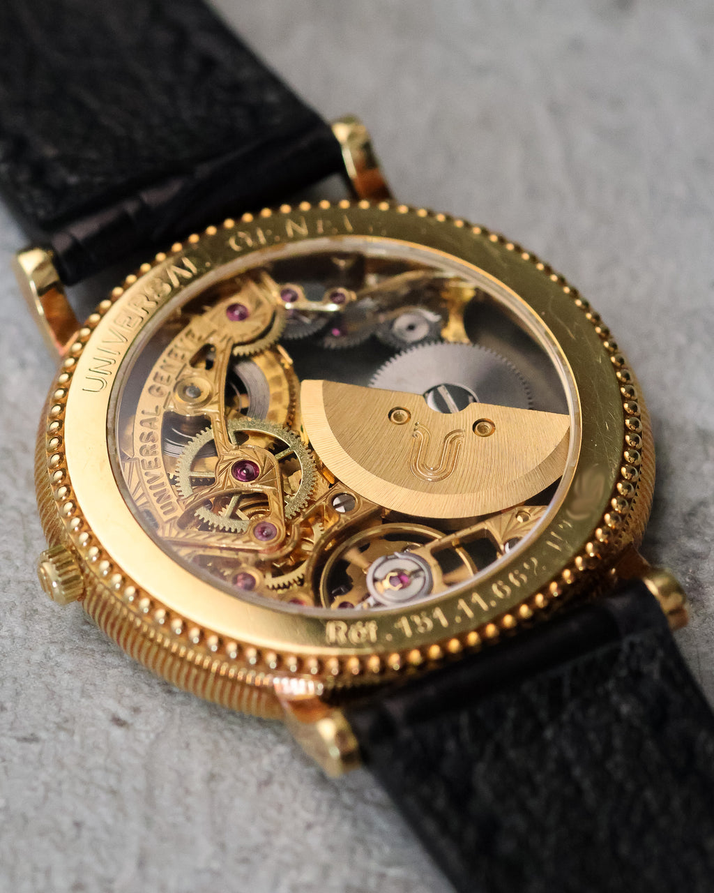 Rear three-quarter view of the micro-rotor movement, showcasing the engraved rotor, ruby jewels, and open architecture beneath the sapphire caseback.